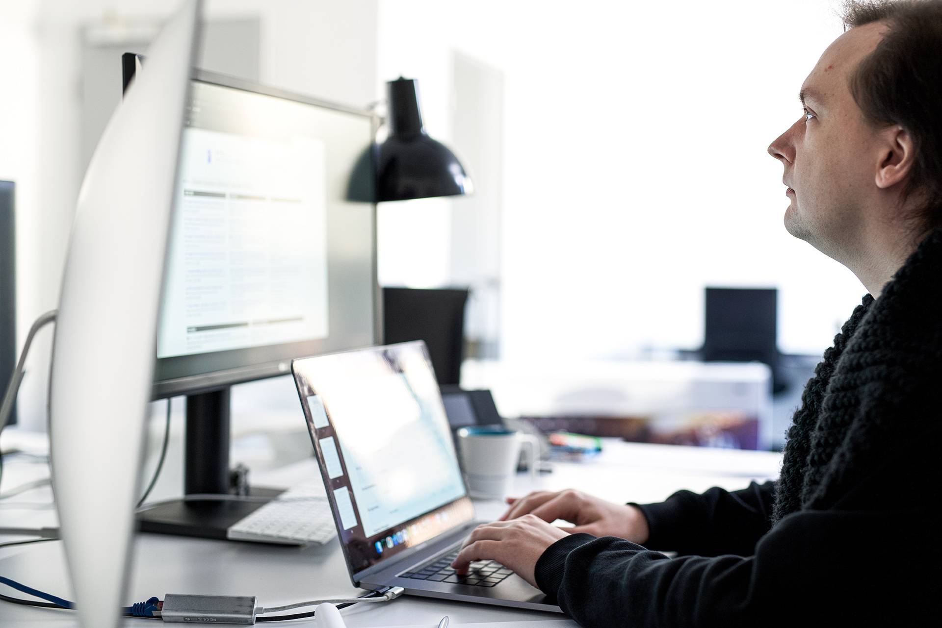 An online marketing expert is intently working on a report at the computer
