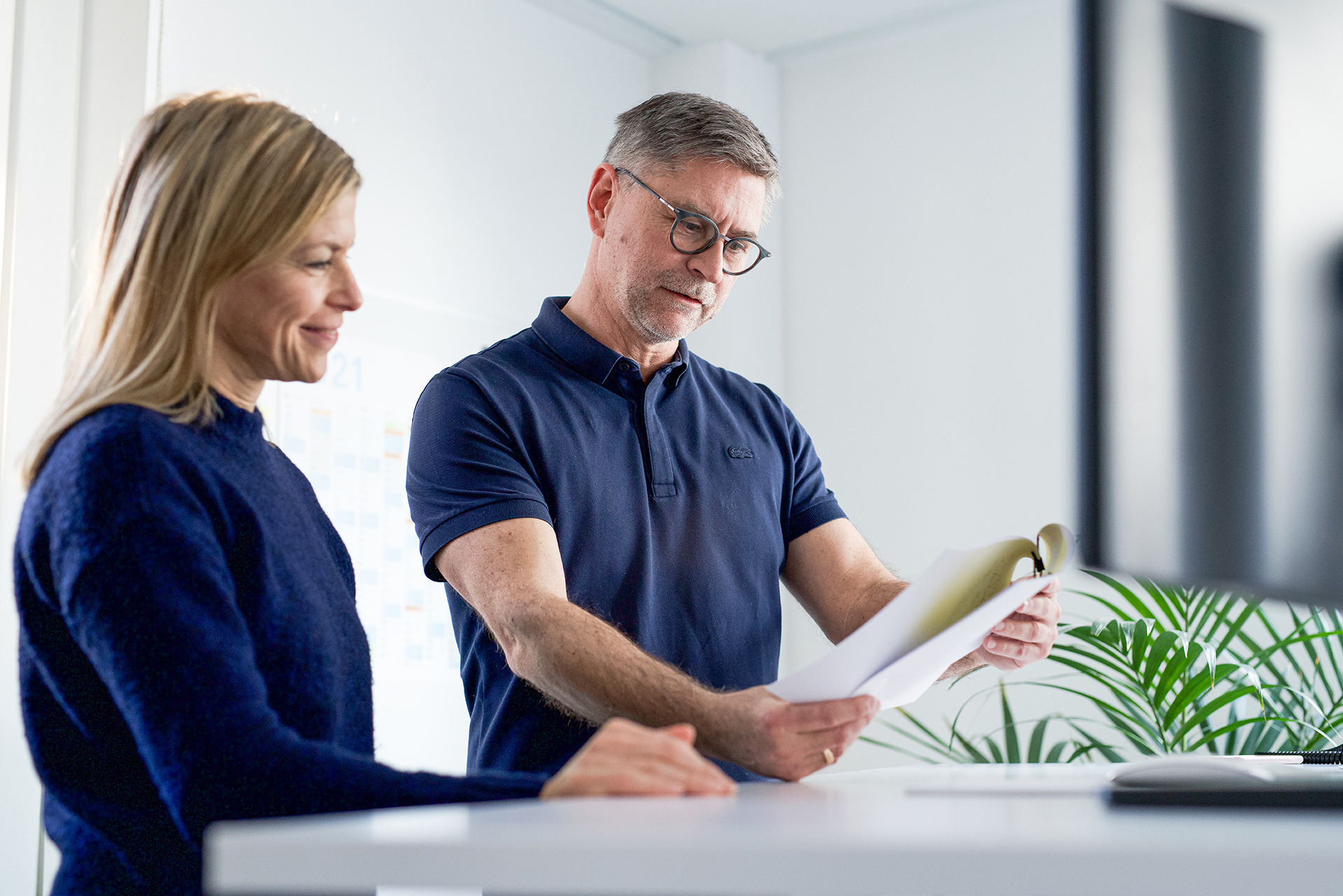 Two agency employees are reviewing a document